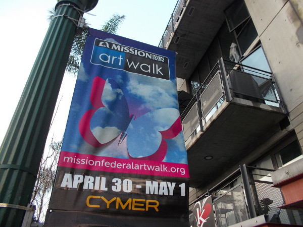 Banner on a street lamp advertises the upcoming Mission Federal Art Walk in Little Italy. It's about a month away.