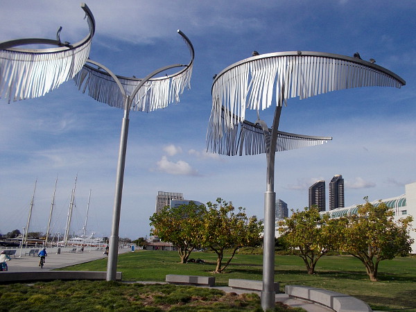 Silvery, sun-reflecting stainless steel ribbon leaves of the Wind Palms move very slightly in the sea breeze.