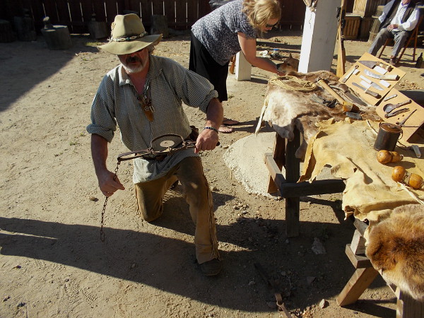 A demonstration of how trappers in the Old West would set a beaver trap by a river and anchor it to a strong stick in the mud.