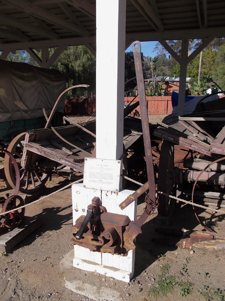 This rusty tool with a long handle is a tyre shrinker. It was used for routine maintenance in the olden days--reducing the diameter of the iron tyres found on wooden wagon, cart and buggy wheels.