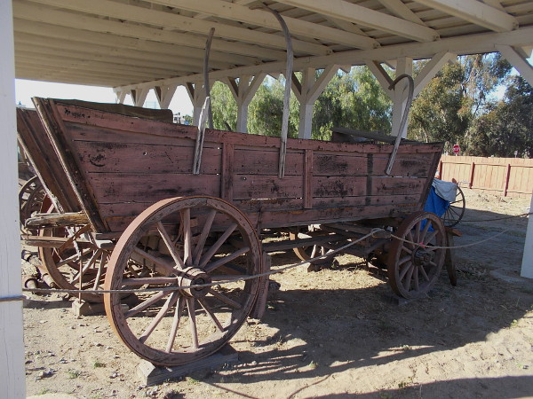 An old covered wagon on display behind Seeley Stable. They were typically sturdy farm wagons with a canvas top. Covered wagons were used on trail drives and cross-country treks.