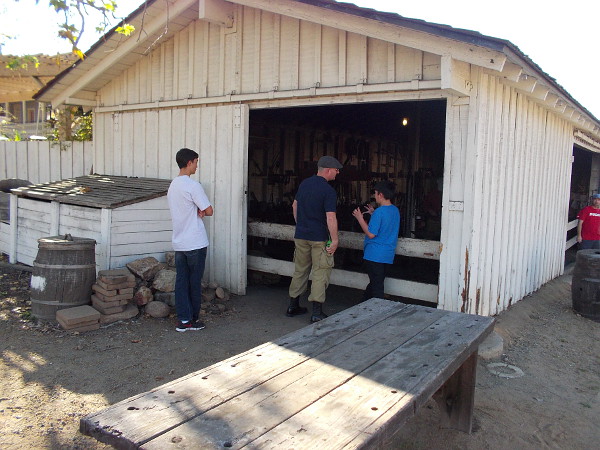 Some park visitors look into the small blacksmith building.