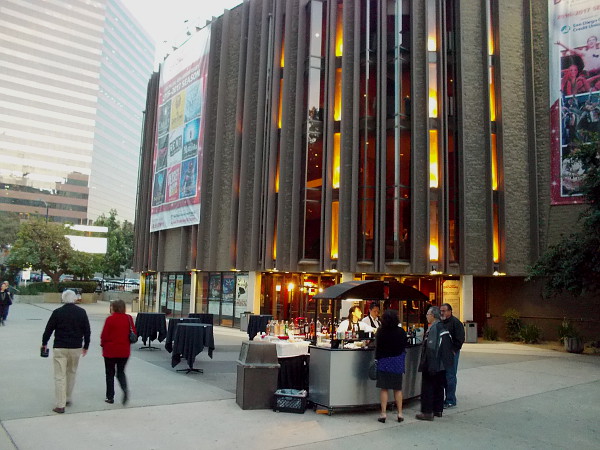 People arrive to watch The Book of Mormon as night approaches and lights come on in downtown San Diego.