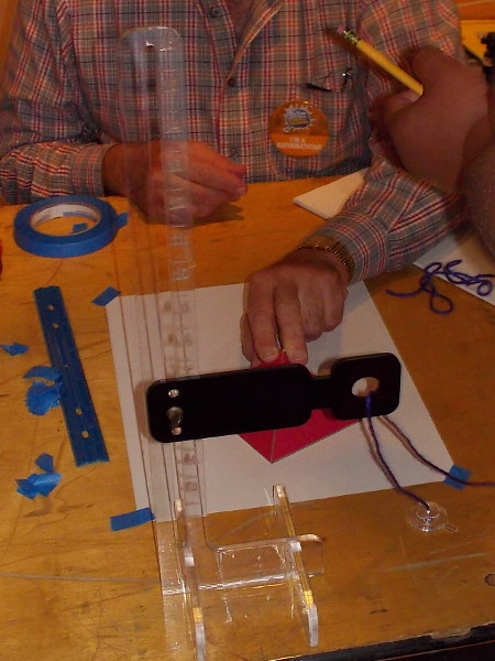 By using a string attached to this tower, you can plot the projected corners of a cube or other three dimensional object onto a flat two dimensional surface.