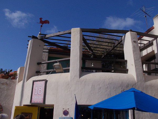 Studio 18 is now the office of Spanish Village Art Center. In the early years a caretaker lived here. That rooster weather vane can be seen in many old photographs.