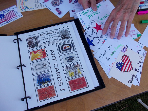 Hand-drawn art cards with hearts and flags thank service members for their sacrifice.