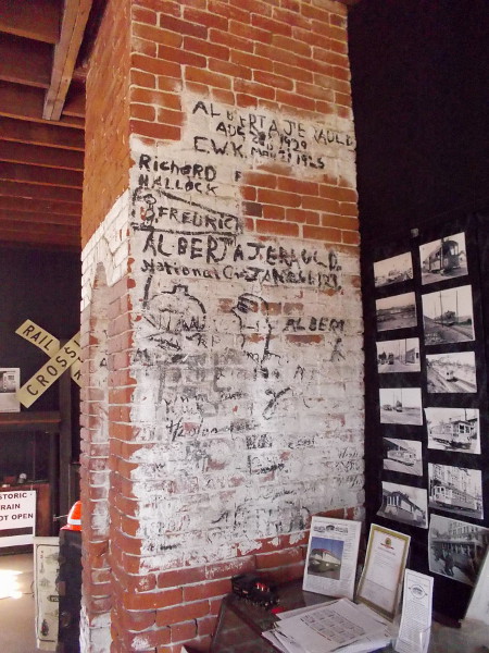 Faded writing on the brick fireplace recalls when the eventually abandoned depot was used as a restaurant. Black panels on the walls cover graffiti.