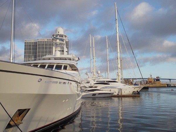 White superyachts docked behind the San Diego Convention Center are bathed in late afternoon light.