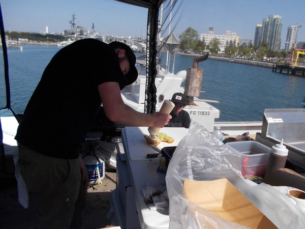 Oh, man! My fish sandwich is getting ready! Some tomatoes, avocado (yum), red onions, chipotle mayo, lettuce, all on a fresh bolillo roll. And grilled fresh fish!
