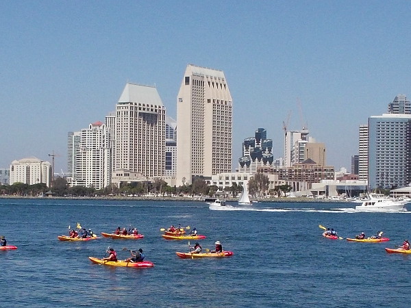 That big group of kayakers is rowing toward the Coronado Ferry Landing. The Manchester Grand Hyatt towers rise across the bay.