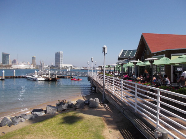 Some kayakers are passing the dock at Peohe's, as outside diners watch. Night views of downtown San Diego lit up across the water are awesome.