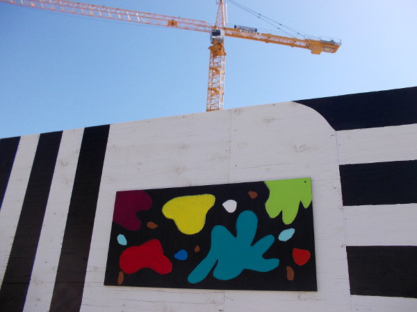 A big construction crane in downtown San Diego rises over globs of color.