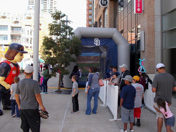 A friendly Coast Guard mascot attracts as much attention from kids as the nearby inflatable batting cage.