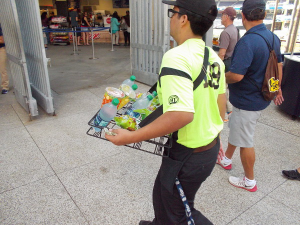 A busy vendor walks about with drinks and snacks.