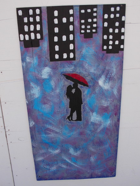 A couple, a red umbrella, and city lights.