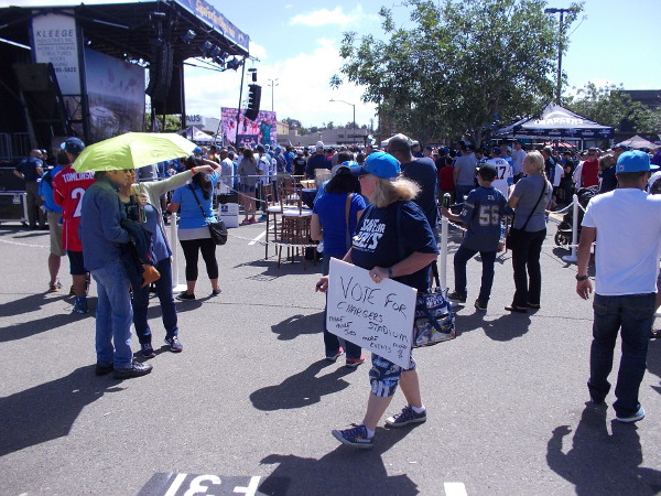 Someone in the gathering crowd holds a Vote for Chargers Stadium sign.