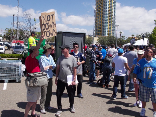 After the event is over, someone holds up a cardboard Not Downtown poster. There are many interested people on both sides of the issue.
