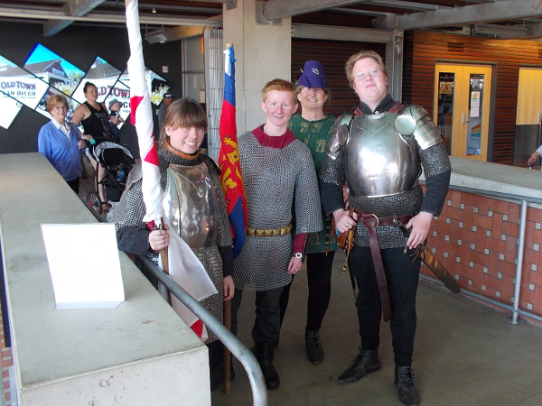 Performers in medieval chain mail and shining breastplate armor pose inside the main entrance of the San Diego Central Library downtown!