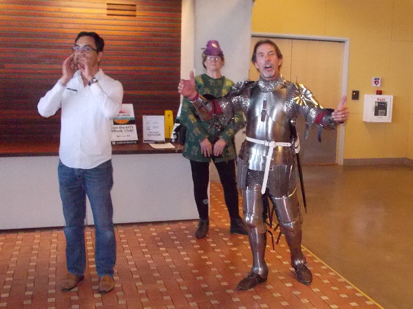 Henry V inspires his troops in the Age of Chivalry, while historical commentary is provided in a modern library. The performance was part of an ongoing summer-long First Folio celebration of Shakespeare.