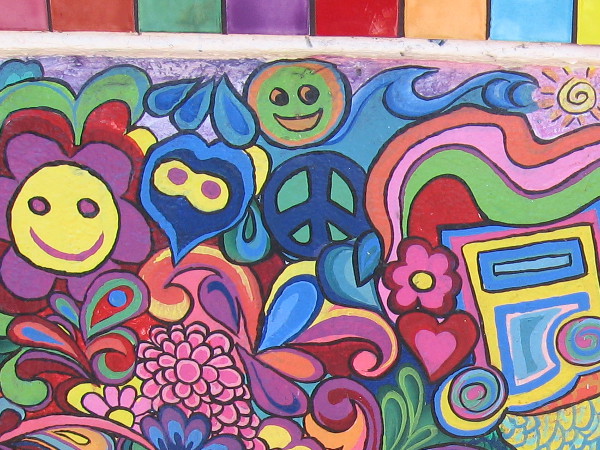 Happy smileys and a peace sign within some rainbowy, swirly 60's style artwork at the USA Hostels Ocean Beach.
