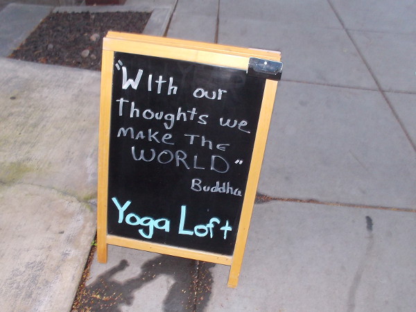 Sign on San Diego sidewalk. With our thoughts we make the world. Buddha.