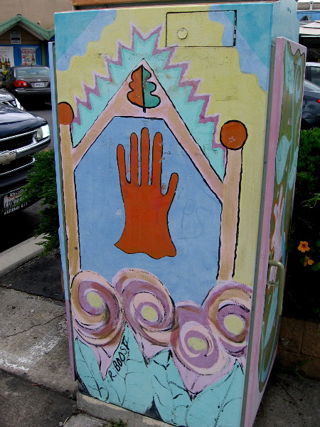 Another side of the same utility box. A hand stands treelike at the center of the unusual metal canvas.