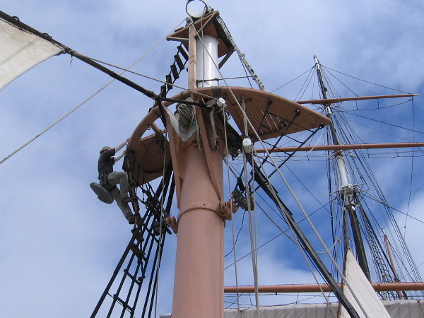 Climbing carefully up to the very top of the foremast to apply a protective cap, to prevent exposed iron from rusting, decaying.