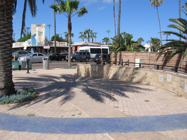Moving shadow in a small plaza at the corner of Sunset Cliffs and W. Point Loma Boulevard. Wisdom and love are written on an Ocean Beach wall.
