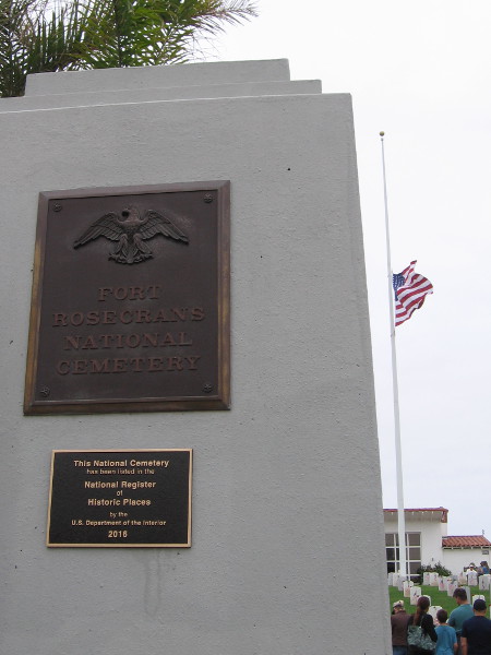 The main entrance plaque at Fort Rosecrans National Cemetery. The flag flies at half staff.