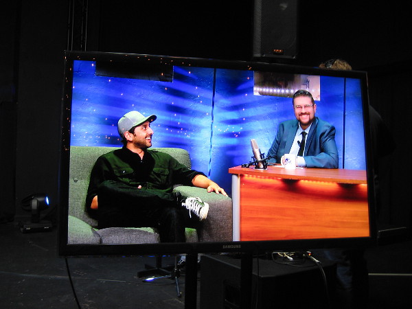 A video screen off to one side shows what actually appears on television. Here Jesse Egan is having a laugh with musician Mike Pinto.