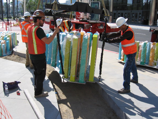 Construction workers carefully install new public art near the Marriott Marquis hotel's conference center. The colorful pylons are part of a sculptural creation titled Tide.