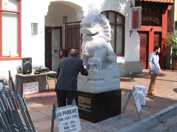 Founder of the San Diego Chinese Historical Museum, Dr. Alexander Chuang, prepares one of two stone lions for their unveiling ceremony.
