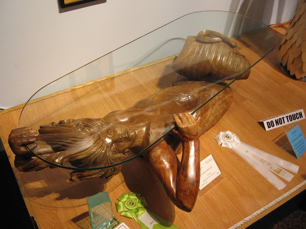 Glass table supported by fantastic underwater character carved from wood. Califa's Realm, Avocado, Lorenzo Foncerrada.