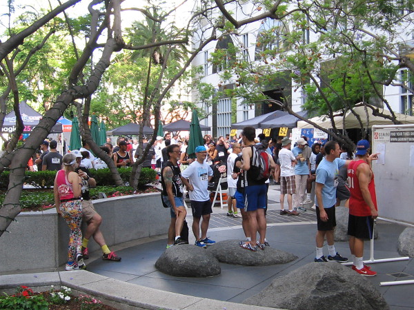 Participants in the charitable stair climb check the standings board in the plaza in front of 550 Corporate Center.