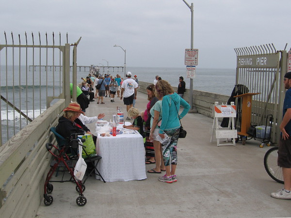 A table near the OB Pier gate welcomes people to the 50th anniversary celebration with flyers and event info.