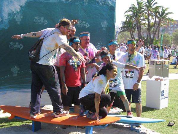 Friends posing for a photo on surfboards at Waterfront Park during the MLB All-Star 5K Color Run.