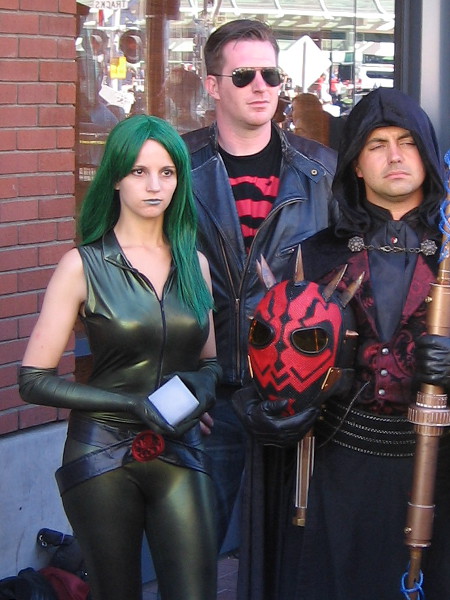 Cosplay enthusiasts stand by during a local television interview outside San Diego Comic-Con.