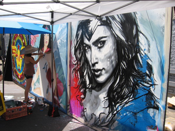 And the right panel, the strong face of comic book heroine Wonder Woman, is being painted by Los Angeles artist Christina Angelina.
