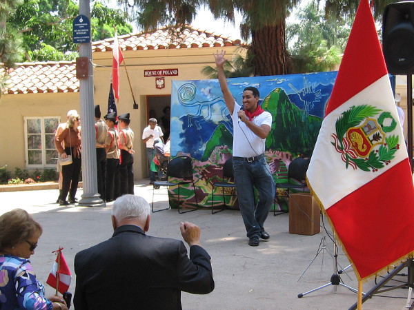 Hearty greetings were offered to everyone attending. Many in the audience had roots in Peru. A mural backdrop depicts Machu Picchu.