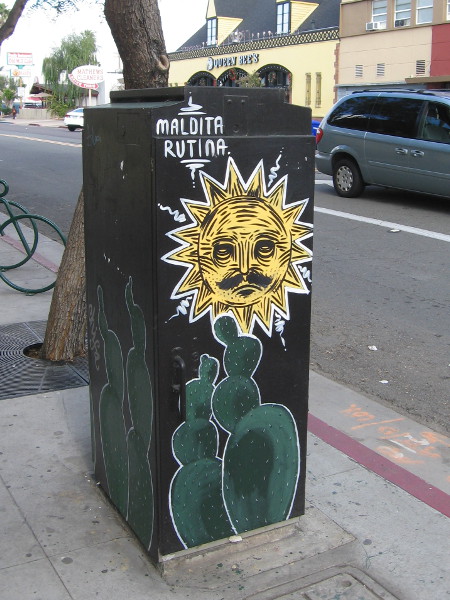 A cool sun with mustache above some prickly pear cacti.