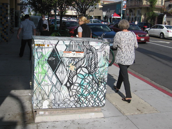 Just walking along the sidewalk, past a creatively decorated transformer box.