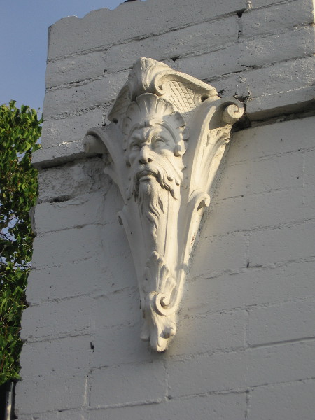 Classic bearded face provides a building wall with sculptural ornamentation.