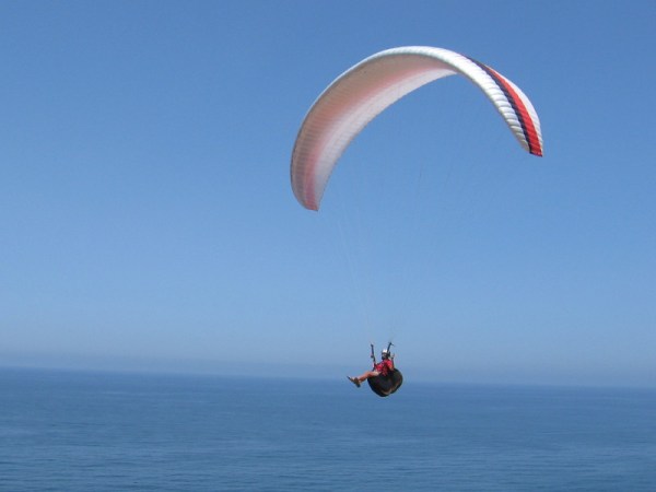 A tranquil ride above and through the beautiful blue. Paragliders wind their way back and forth along the cliffs, catching the updraft.