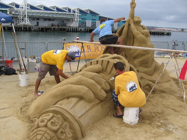 Talented sand sculptors work on the flaming torch from New York's Statue of Liberty.