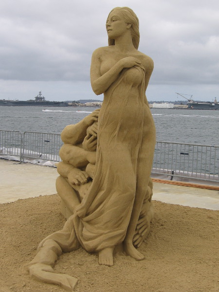 Many hands reach for a very beautiful woman, but she is out of reach.