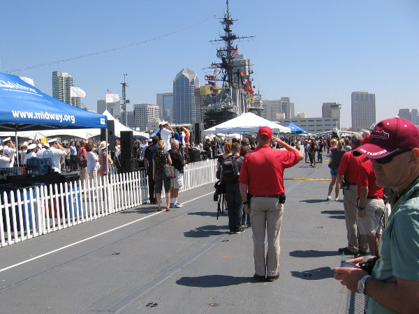USS Midway Museum volunteer salutes the American flag while the Star Spangled Banner is sung.