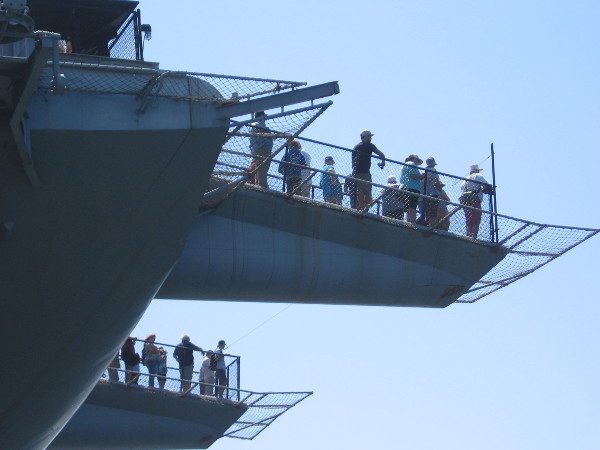 People watch the Sea and Air Parade from launch ramps at the bow of the USS Midway.