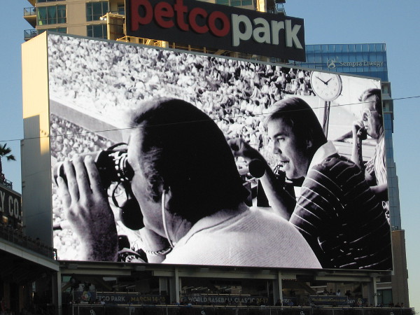 Remembering a sports broadcasting legend. A photo of a young Dick Enberg is flashed on the Petco Park videoboard, celebrating the Padres broadcaster during the 2016 season's final home game.
