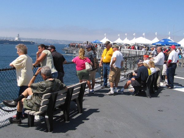 People on the flight deck of USS Midway take in sunshine and military pageantry during Fleet Week in San Diego.