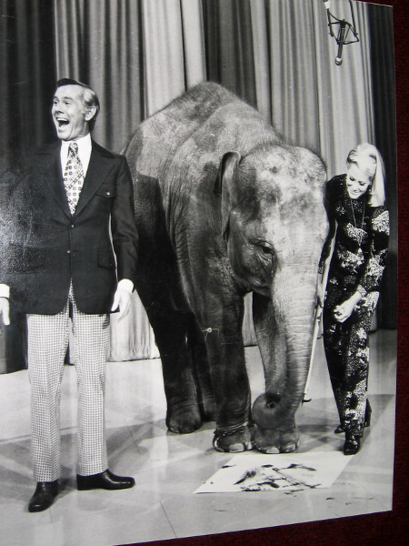 Joan Embery appears with Johnny Carson on the Tonight Show. Carol the Elephant paints on a canvas for the national audience.